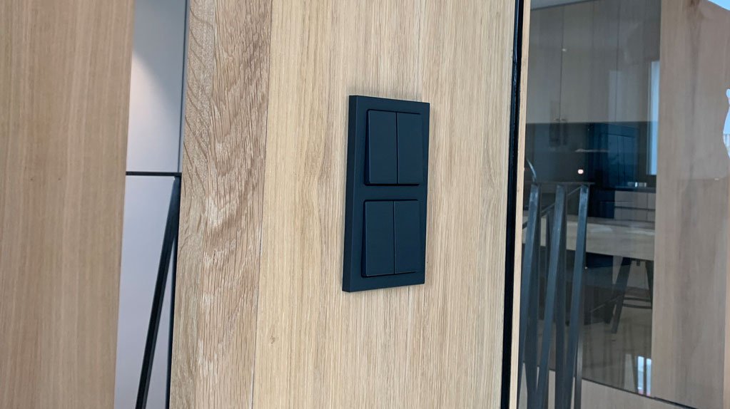 Elektroinstallation in einem Neubau - schwarze Lichtschalter in der Holzwand eines modernen Bürogebäudes